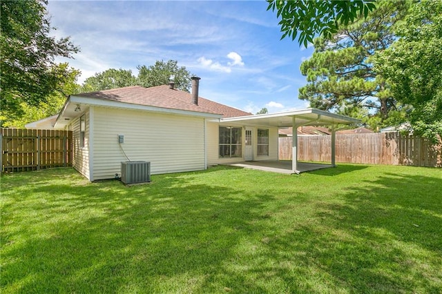 back of house featuring a lawn, cooling unit, and a patio area