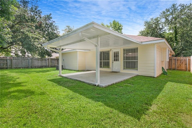 back of property with a lawn and a patio area