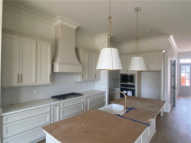 kitchen with pendant lighting, an island with sink, appliances with stainless steel finishes, and sink