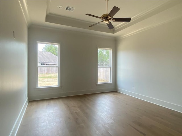 spare room featuring a tray ceiling, ornamental molding, ceiling fan, and hardwood / wood-style flooring