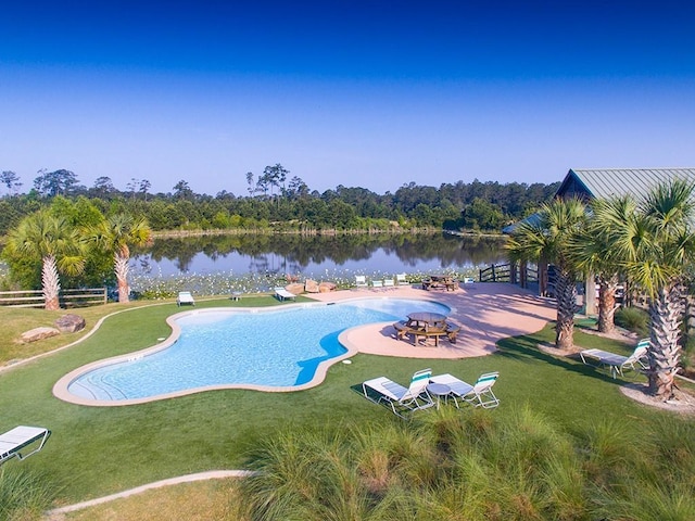 view of swimming pool with a water view, a yard, and a patio area