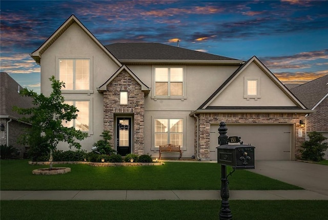 view of front facade featuring a garage, a yard, driveway, and stucco siding