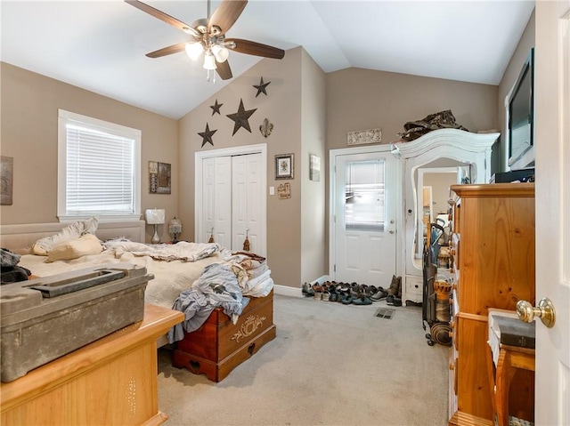 bedroom with lofted ceiling, a closet, carpet floors, and ceiling fan