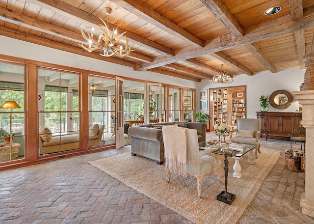 living room featuring beamed ceiling, wood ceiling, and an inviting chandelier