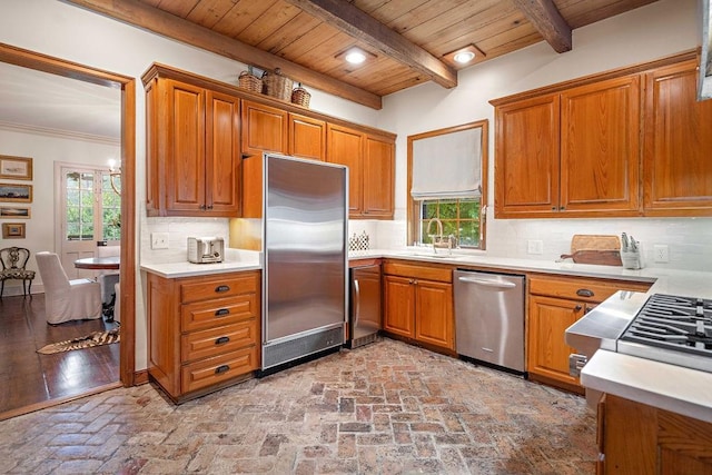 kitchen featuring tasteful backsplash, sink, beamed ceiling, and stainless steel appliances