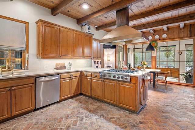 kitchen with sink, kitchen peninsula, pendant lighting, appliances with stainless steel finishes, and custom exhaust hood