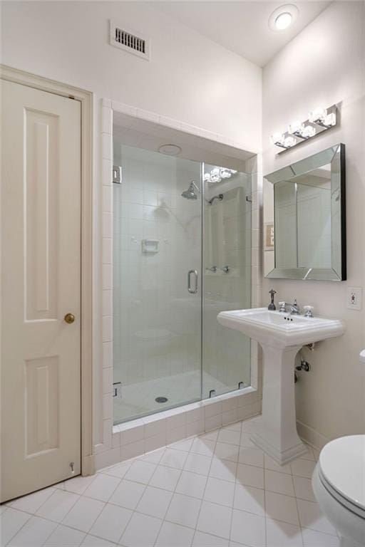 bathroom with tile patterned floors, toilet, and walk in shower