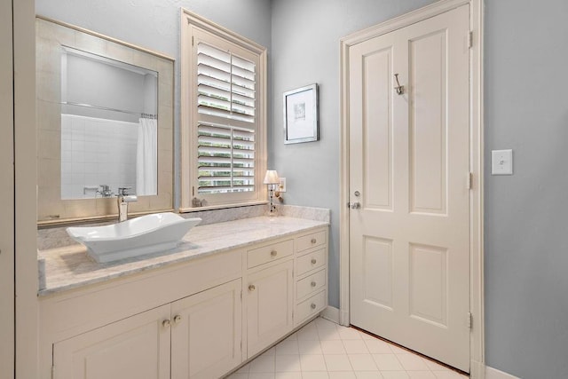 bathroom with a shower with curtain, vanity, and tile patterned floors