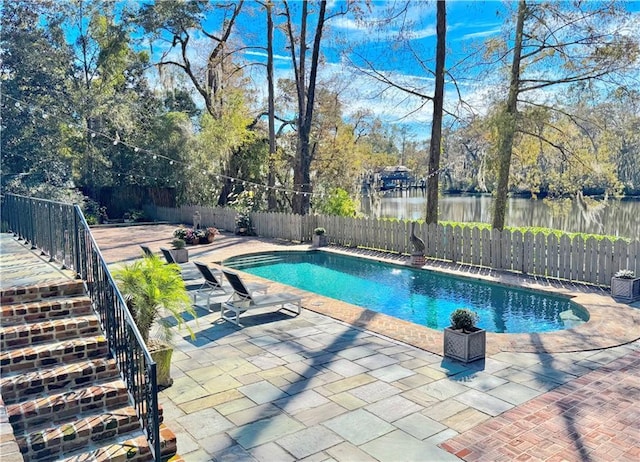 view of pool with a patio area and a water view