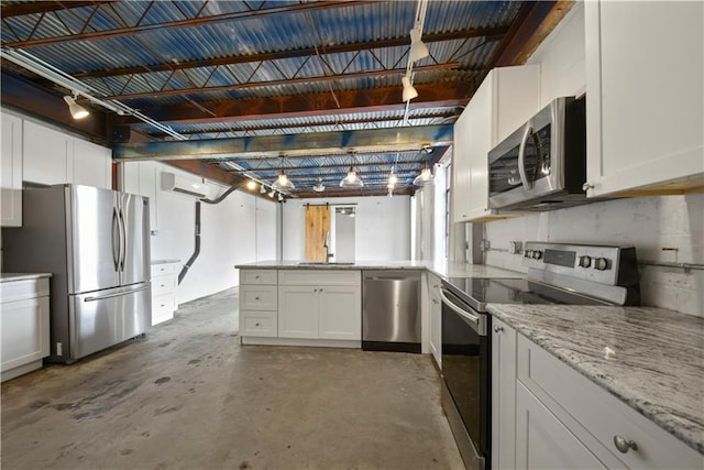 kitchen featuring appliances with stainless steel finishes, white cabinetry, a wall unit AC, decorative light fixtures, and light stone countertops