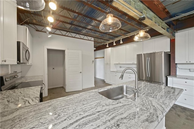 kitchen featuring white cabinetry, hanging light fixtures, stainless steel appliances, light stone countertops, and sink