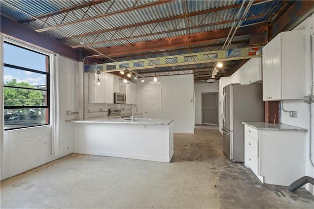 kitchen featuring white cabinets, sink, stainless steel appliances, and kitchen peninsula