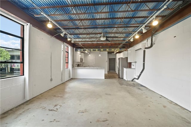 basement featuring an AC wall unit and stainless steel refrigerator