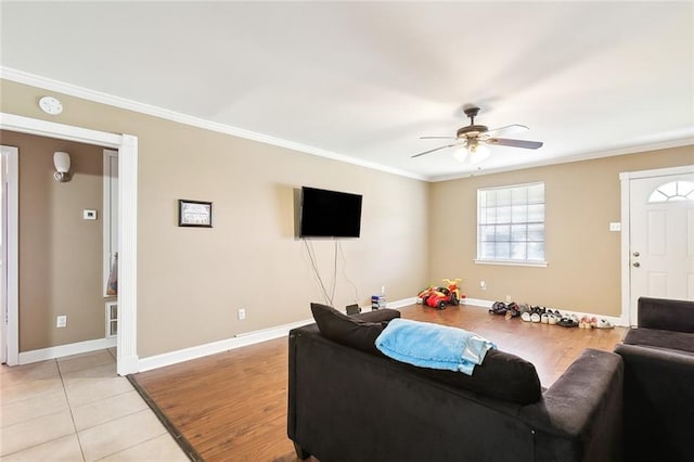 living room featuring ceiling fan, ornamental molding, and light hardwood / wood-style floors