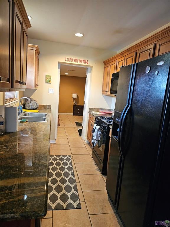 kitchen with sink, black appliances, and light tile patterned floors