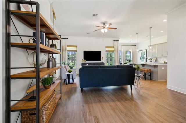 living room with ceiling fan, hardwood / wood-style flooring, and crown molding