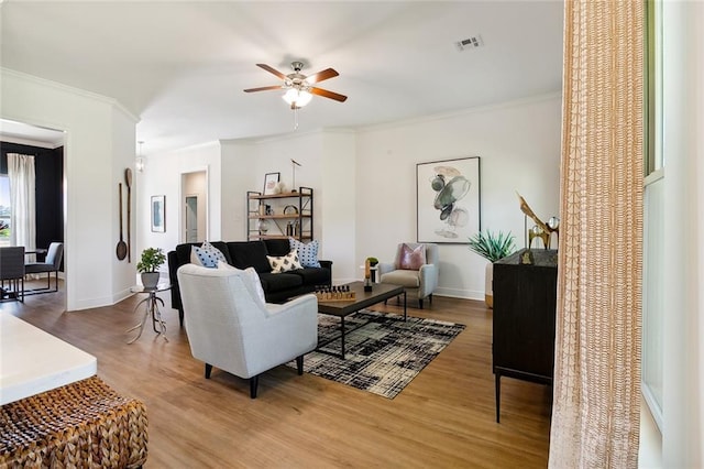 living room featuring ceiling fan, crown molding, and wood-type flooring