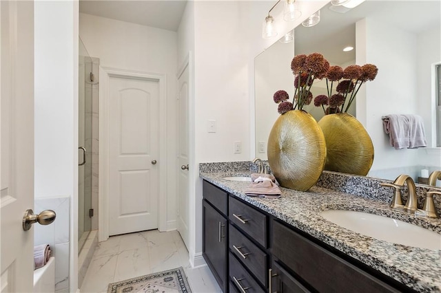 bathroom featuring a shower with door and vanity