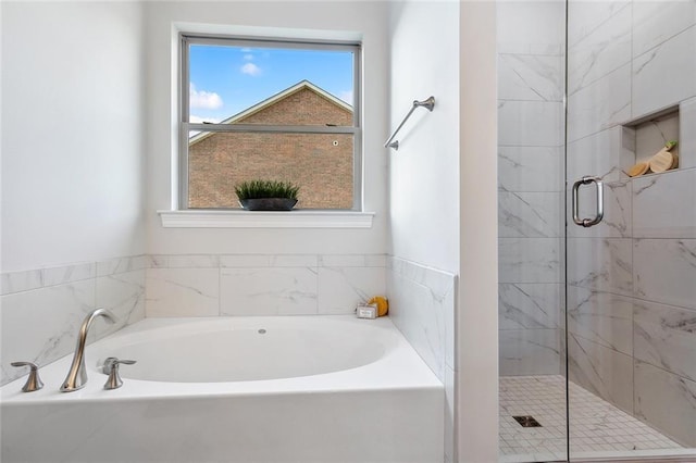 bathroom with a wealth of natural light and separate shower and tub