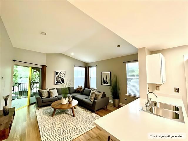 350 Emerald Forest Blvd Unit 13204, Covington, LA 70433 - living area featuring healthy amount of natural light, lofted ceiling, wood finished floors, and baseboards