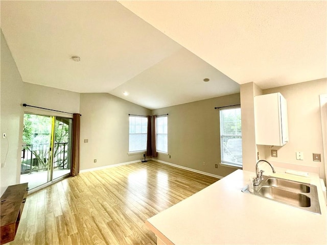 350 Emerald Forest Blvd Unit 13204, Covington, LA 70433 - kitchen featuring a sink, white cabinetry, light wood-type flooring, vaulted ceiling, and light countertops