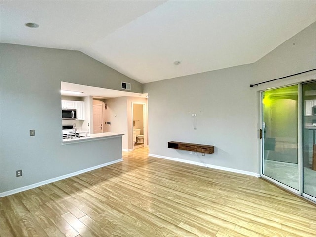 unfurnished living room with light hardwood / wood-style flooring and vaulted ceiling