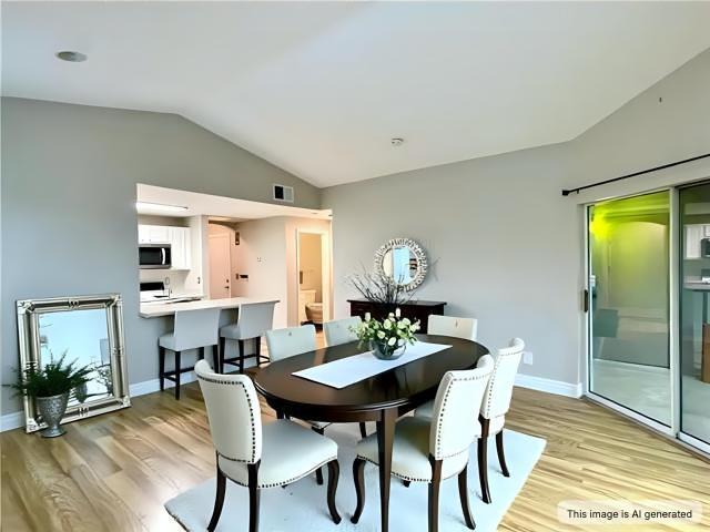 350 Emerald Forest Blvd Unit 13204, Covington, LA 70433 - dining space featuring vaulted ceiling, light wood-style flooring, and baseboards