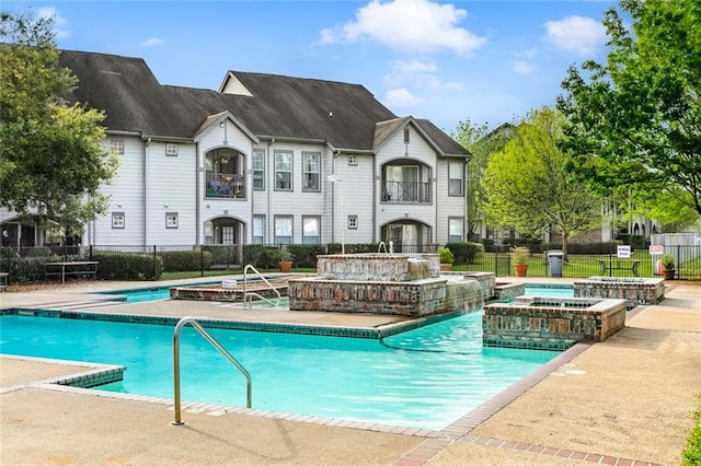 view of pool featuring an in ground hot tub, pool water feature, and a patio area