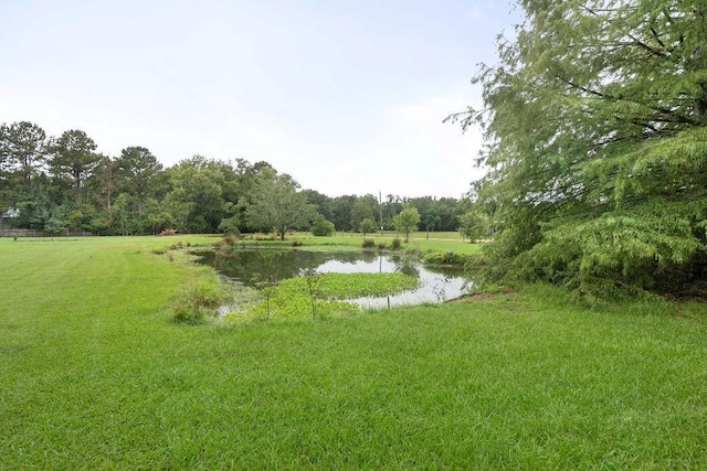 view of home's community featuring a water view and a lawn