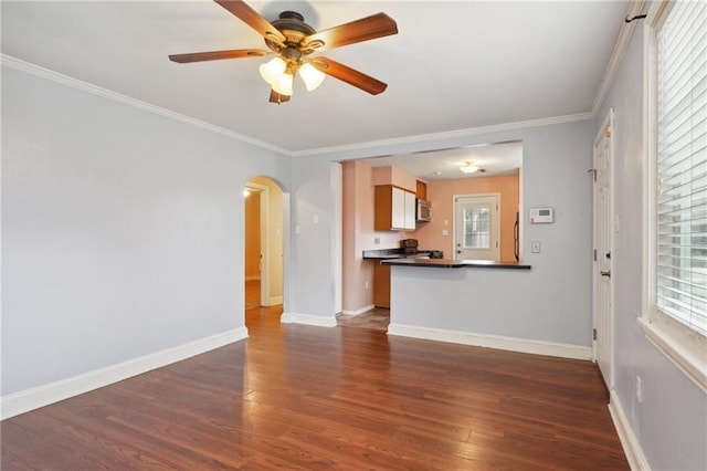 unfurnished living room with dark hardwood / wood-style flooring, ceiling fan, plenty of natural light, and crown molding