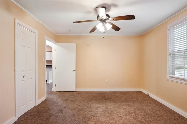 carpeted spare room featuring ornamental molding and ceiling fan