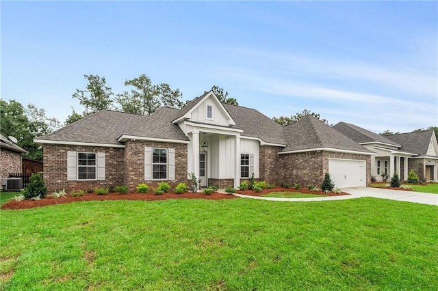 view of front of house with cooling unit, a garage, and a front lawn