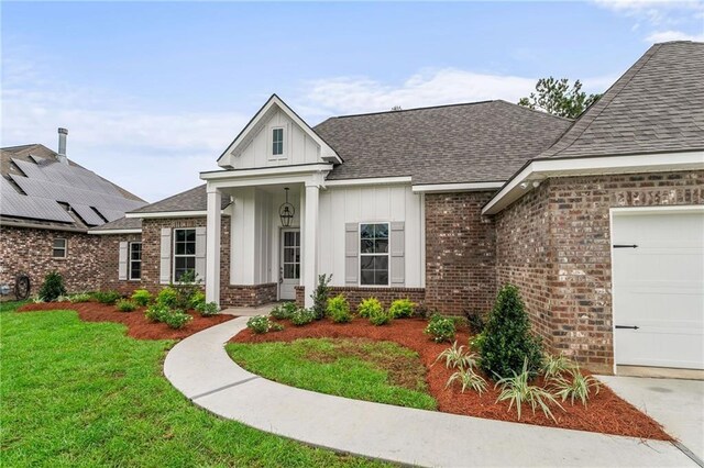 view of front of home featuring a front yard, a garage, and solar panels