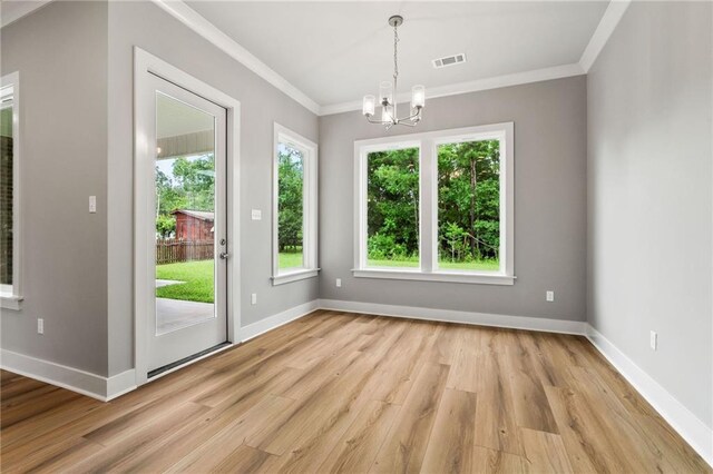 entryway with a notable chandelier, crown molding, and light wood-type flooring