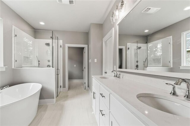 bathroom featuring tile patterned flooring, independent shower and bath, and vanity