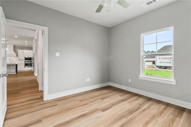 unfurnished room with ceiling fan and light wood-type flooring