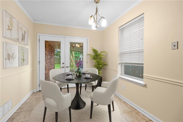 dining area featuring ornamental molding, light tile patterned flooring, an inviting chandelier, and french doors