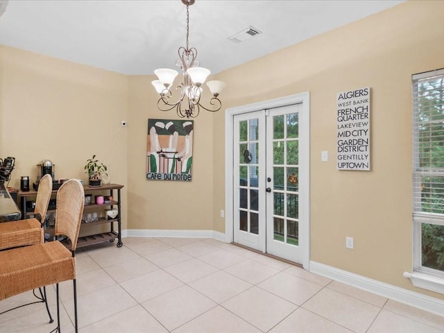 doorway with light tile patterned flooring, a healthy amount of sunlight, an inviting chandelier, and french doors