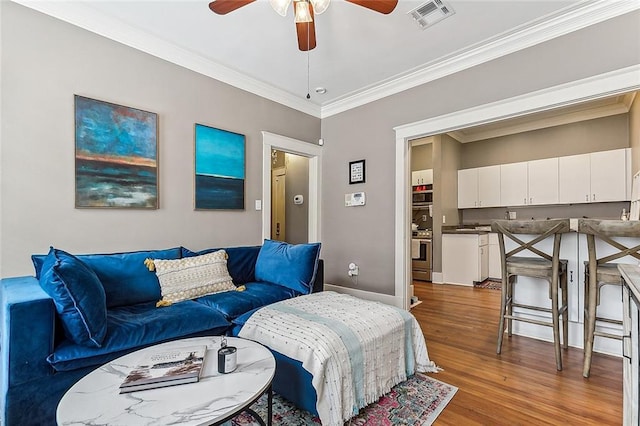 living room with ceiling fan, ornamental molding, and hardwood / wood-style floors