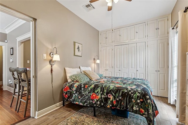 bedroom featuring ceiling fan, light hardwood / wood-style floors, a closet, and crown molding