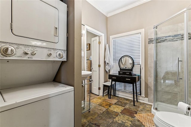 laundry room with crown molding and stacked washer / dryer