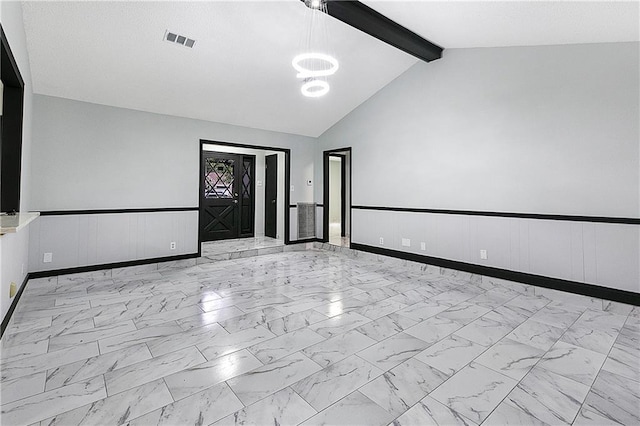 empty room with vaulted ceiling with beams