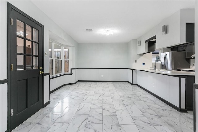 kitchen featuring sink, white cabinets, and stainless steel refrigerator with ice dispenser