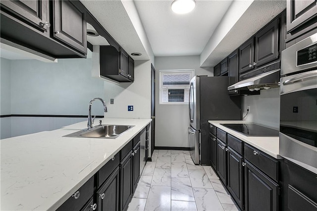 kitchen with light stone counters, stainless steel appliances, and sink