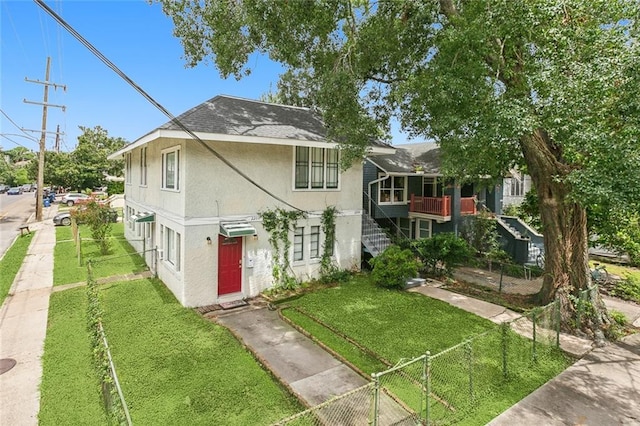 view of front of home featuring a balcony and a front yard