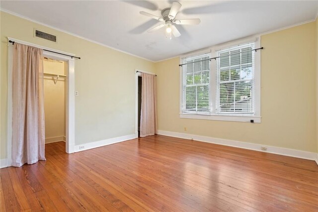 interior space with ceiling fan, hardwood / wood-style flooring, and ornamental molding