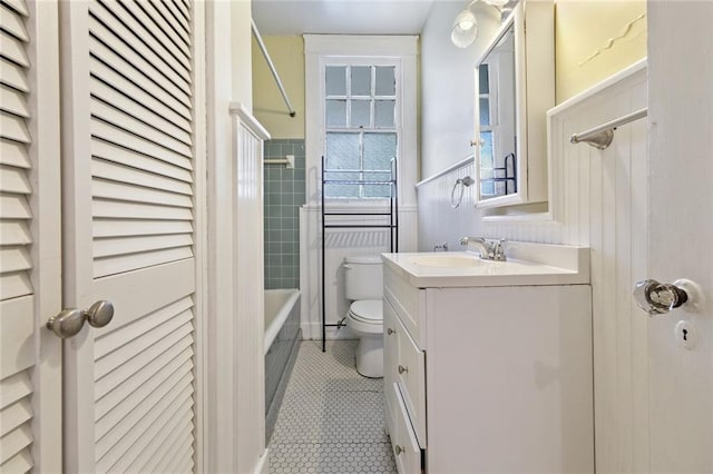 full bathroom featuring vanity, toilet, tiled shower / bath, and tile patterned flooring