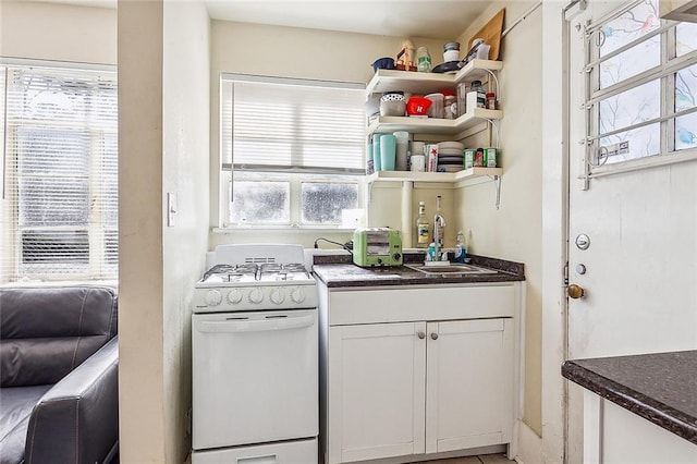220200 Nashville Ave, New Orleans, LA 70115 - kitchen featuring a sink, white cabinets, open shelves, and gas range gas stove