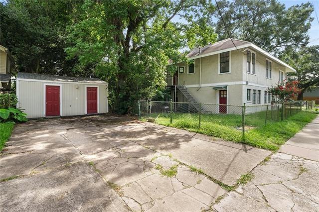 220200 Nashville Ave, New Orleans, LA 70115 - view of home's exterior with stucco siding, a fenced front yard, and an outdoor structure