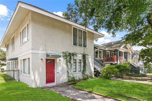 220200 Nashville Ave, New Orleans, LA 70115 - view of front of property with stairs, fence, a front lawn, and stucco siding